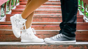 Boy and girl shoes touching on pavement