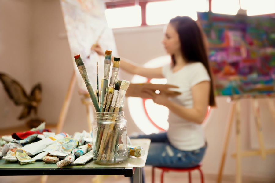 Girl painting on canvas during art class