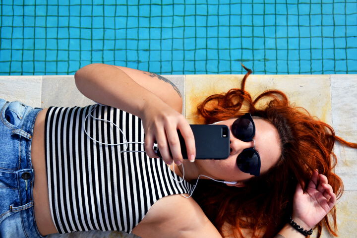 Girl laying on the ground looking at her phone